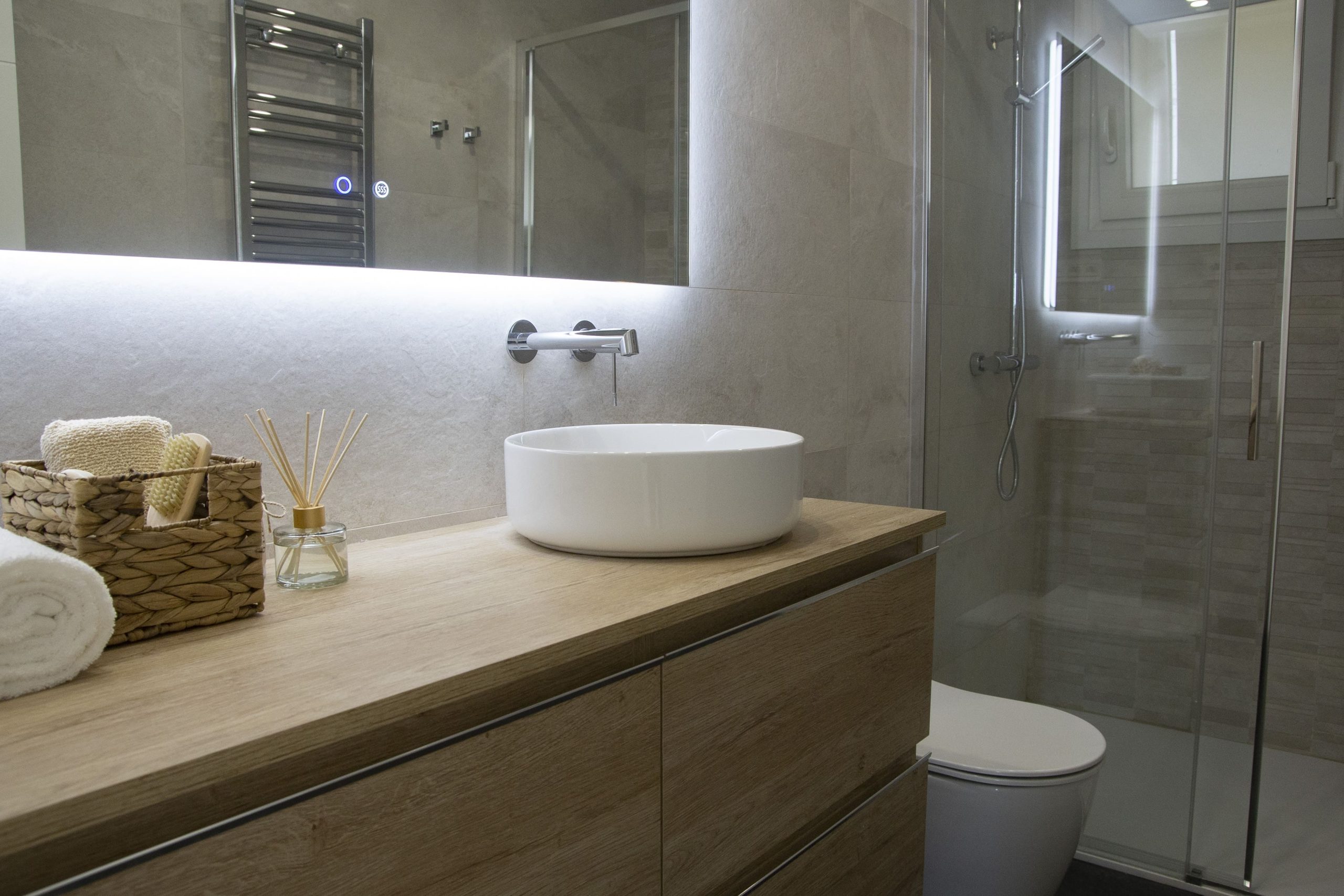 Baño con mueble de madera y mámpara de ducha